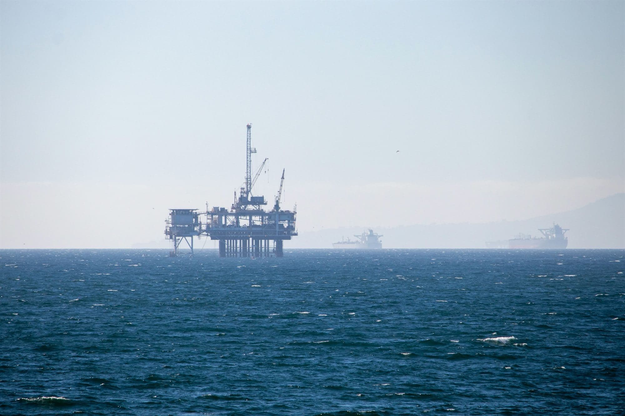 Plateforme pétrolière offshore en mer, sous un ciel clair